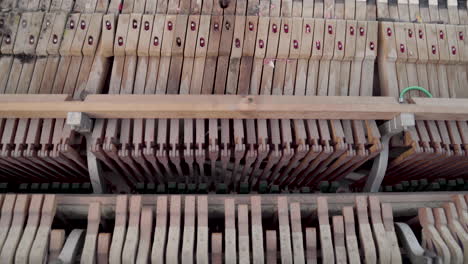 Closeup-of-Woman-Playing-an-Old-Broken-Piano-Top-Down