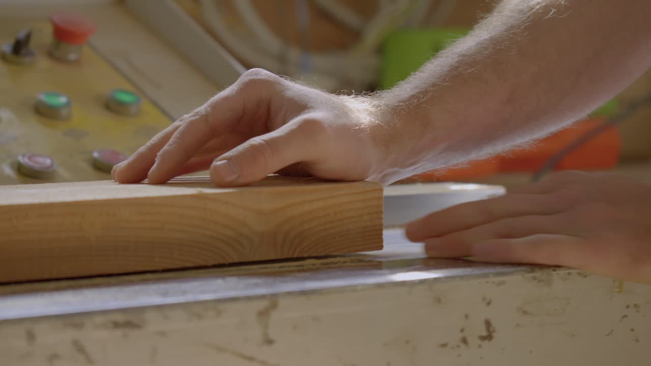 fotografía de cerca de una mano colocada en una tabla de madera en un taller