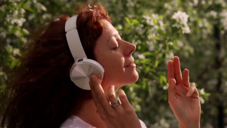 woman listening to music in a blooming orchard