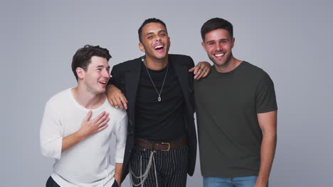 group studio portrait of multi-cultural male friends smiling into camera together in slow motion