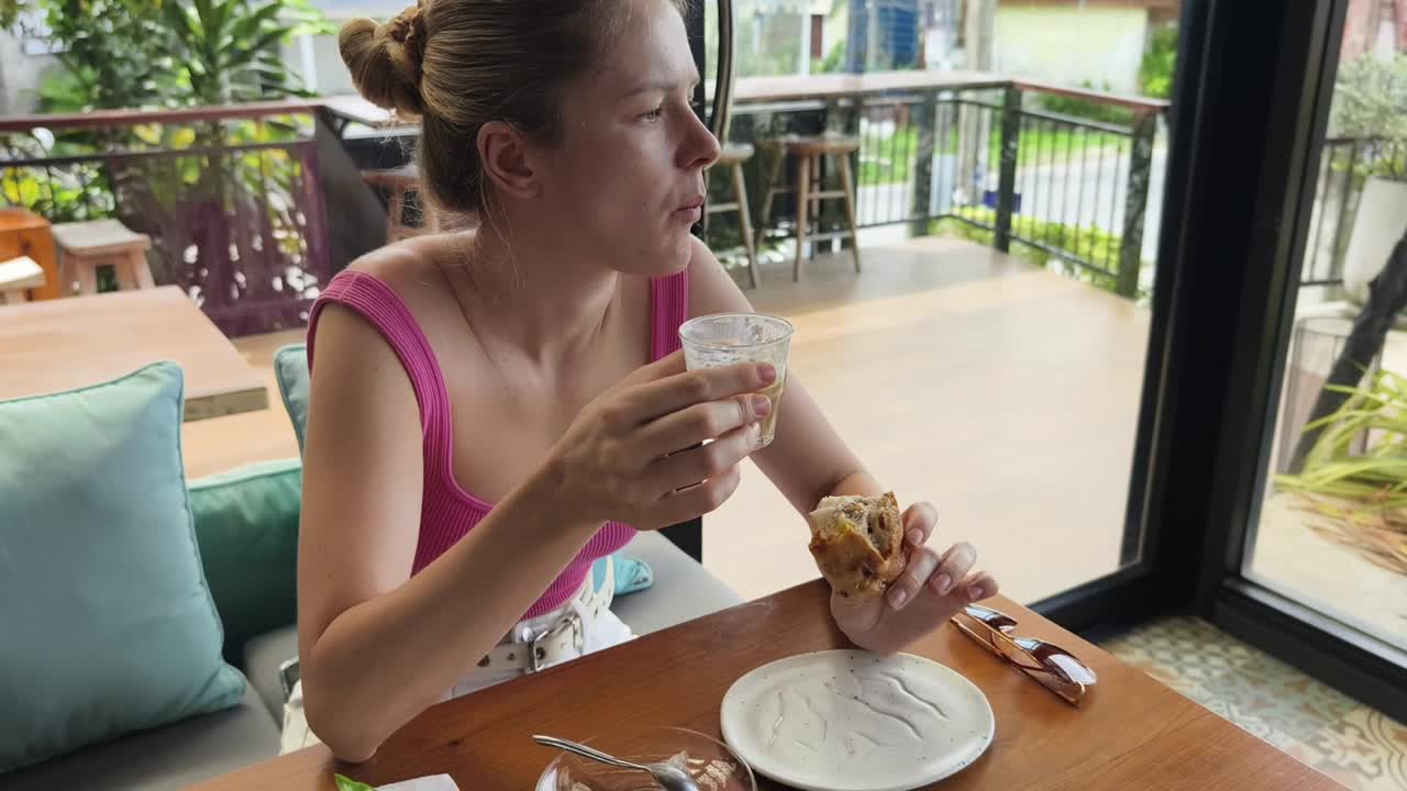 mujer disfrutando de café y pasteles en un café