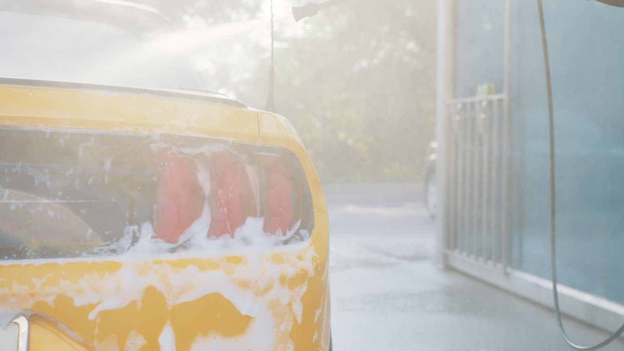 노란색 스포츠카가 세탁장에서 세척되고 있다