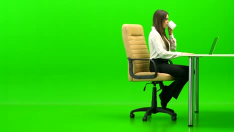 la hermosa mujer relajándose en la mesa sobre el fondo verde