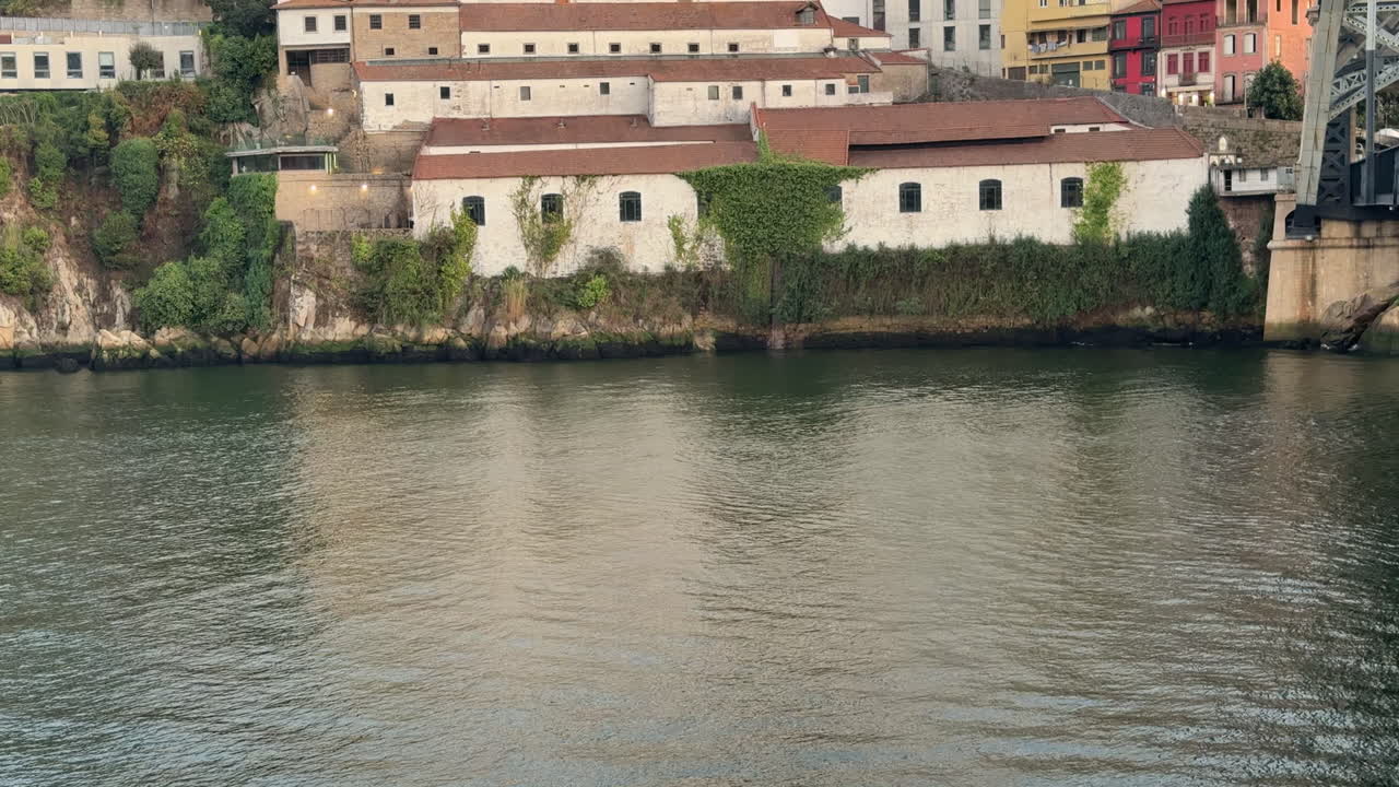 Panned Close-up shot of calm Douro River water surface reflecting the light of the sky and riverside cliffs. Gentle ripples and soft movement make this perfect for background visuals and reflection