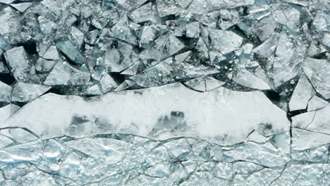 aéreo de arriba hacia abajo, capa de hielo polar agrietada causada por el cambio climático