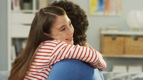 Close-Up-Of-The-Smiled-Cheerful-Small-Teen-Girl-Hugging-Her-Daddy-And-Laughing-At-Home