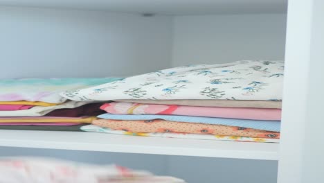 close up of a closet shelf with folded clothes