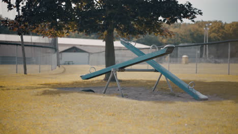 Verlassene,-Leere,-Sich-Bewegende-Wippe,-Die-Im-Herbst-Auf-Dem-Kinderspielplatz-Taumelt.-4k-Prores