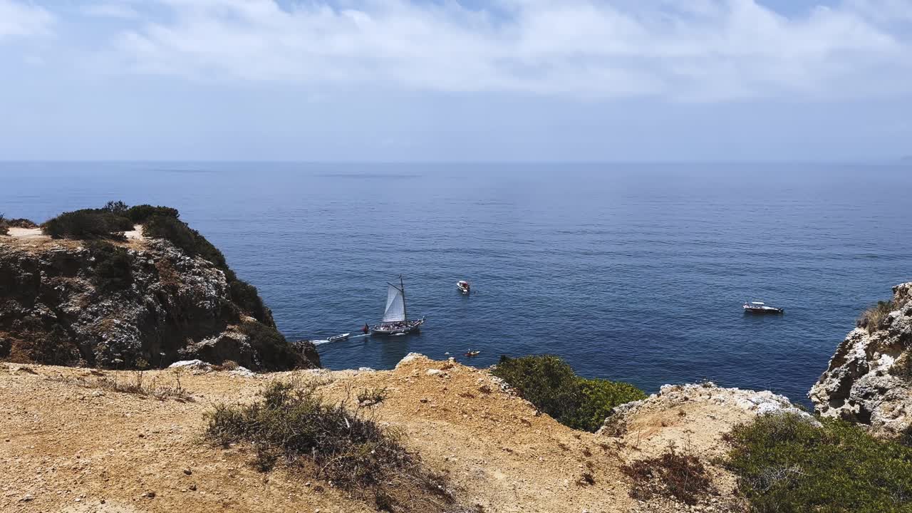 Beautiful footage of the Algarve coast featuring a boat sailing in clear blue water on a sunny day