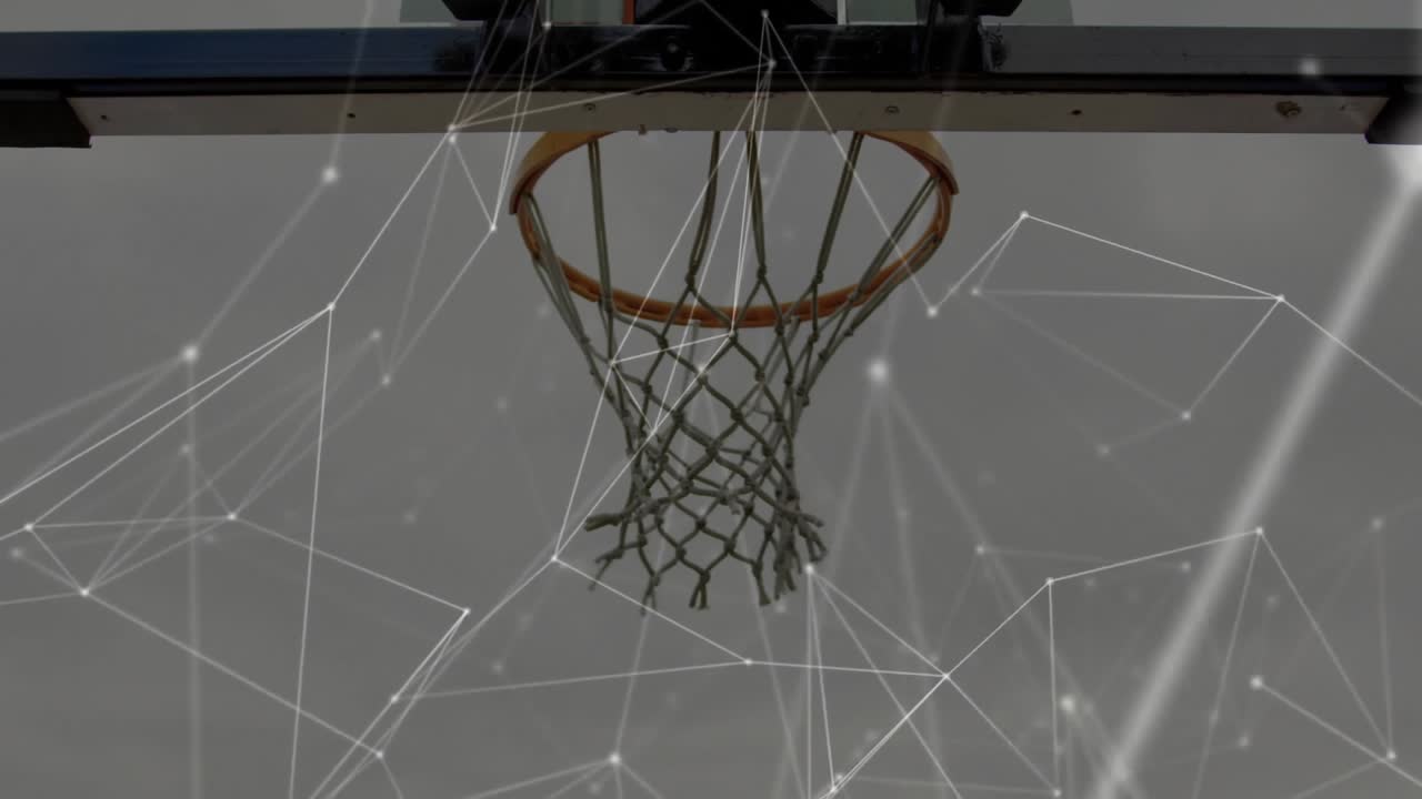 Amici che giocano a basket informale, palleggiando verso il canestro su un campo all'aperto, con un difensore che contesta il tiro mentre la palla si inarca