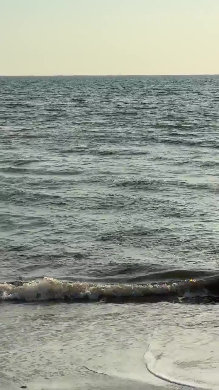 Dolci onde dell'oceano che si infrangono su una spiaggia sabbiosa.