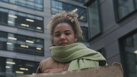 Junge-Amerikanische-Aktivistin-Mit-Einem-Plakat,-Das-Gegen-Den-Klimawandel-Protestiert,-Während-Sie-In-Die-Kamera-Schaut