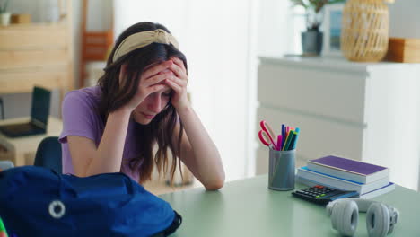 Una-Joven-Estudiante-Triste-Se-Derrumba-Después-De-Regresar-De-La-Escuela-Y-Se-Sienta-Tristemente-En-Su-Escritorio