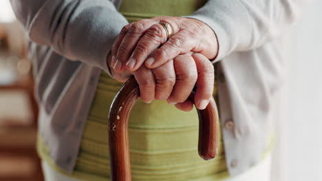 close up of an elderly woman's hands holding a walking cane