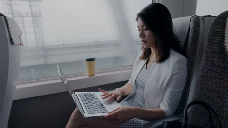 confident businesswoman typing on laptop keyboard, working on tablet, she is typing messages to colleagues and making financial information sheet to sum up the meeting