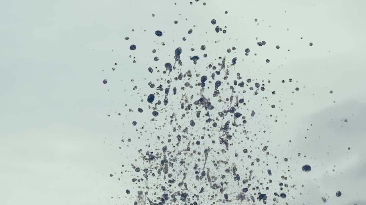 Close-up of fountain water droplets on sunlight. Water splashing. Slow motion