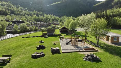 Beautiful-garden-and-recreational-area-outside-Norwegian-Fjord-Centre-in-Geiranger-Norway---Garden-view-before-tilting-up-to-reveal-nature-and-mountain-scenery