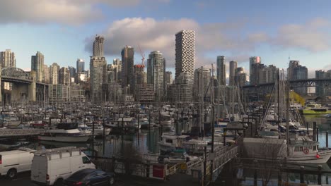 fisherman's wharf marina where small boats are docked anchored at a waterfront and the cityscape with high rise buildings in the background blue sky clouds bridge