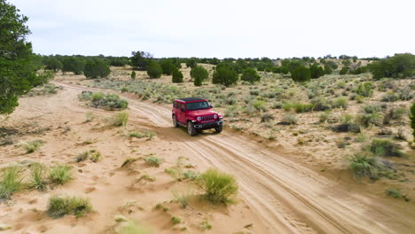 Lone-Red-Jeep-Wrangler-Driving-On-Dirt-Road-Going-To-White-Pocket-In-Utah,-USA