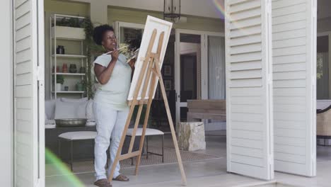 happy senior african american woman painting in slow motion