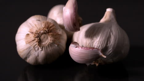 Knoblauch-Fällt-Vor-Schwarzem-Hintergrund