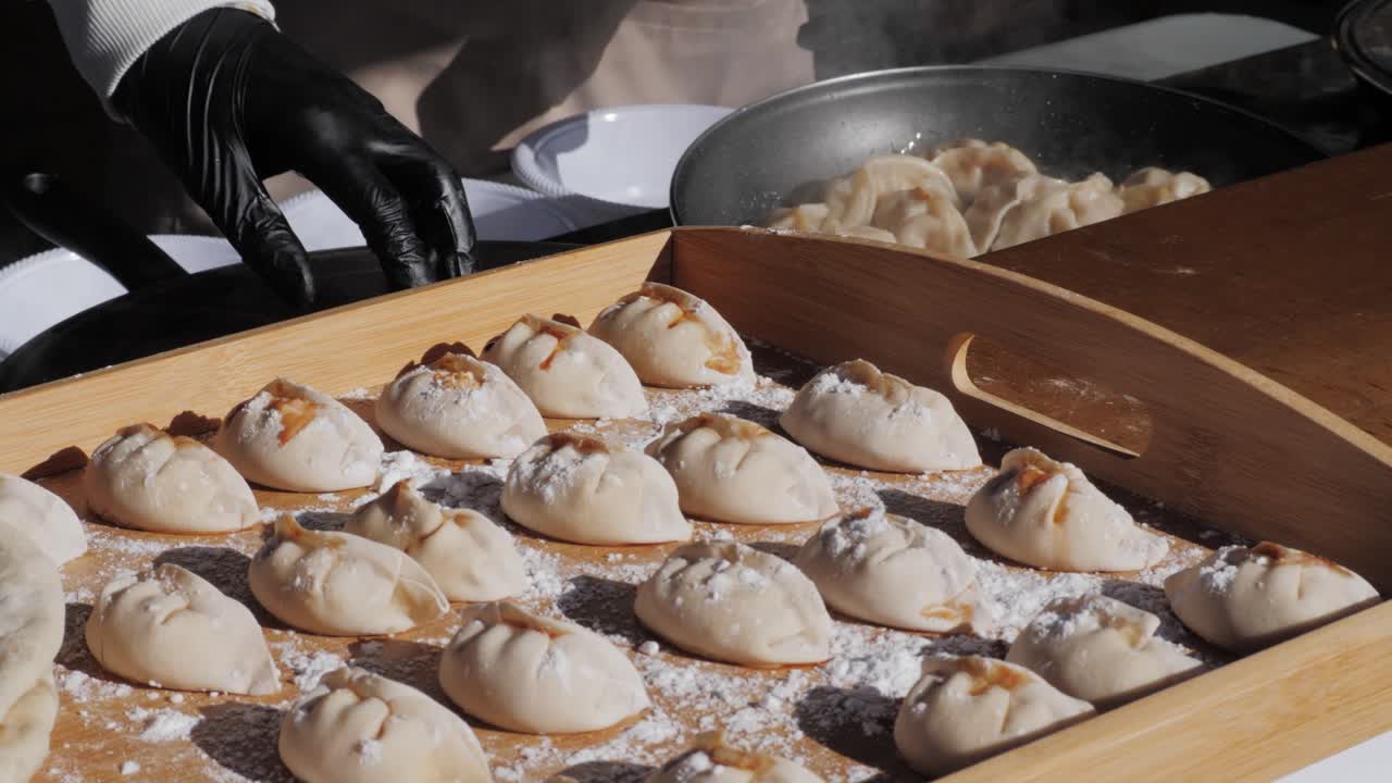 Chinese and Japanese Jiaozi or gyoza on wooden desk close-up. Dumplings with meat pouring red sweet chilli sauce. Cooking at cafe, restaurant. Asian street food market outdoors.High quality 4k footage