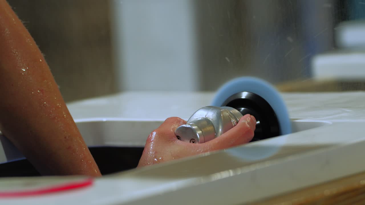 그라나이트 주방 카운터탑 -  ⁇ 츠 - 바위의 근처에서 파란색 폴리셔와 함께 창고에서 물을  ⁇ 는 작업자