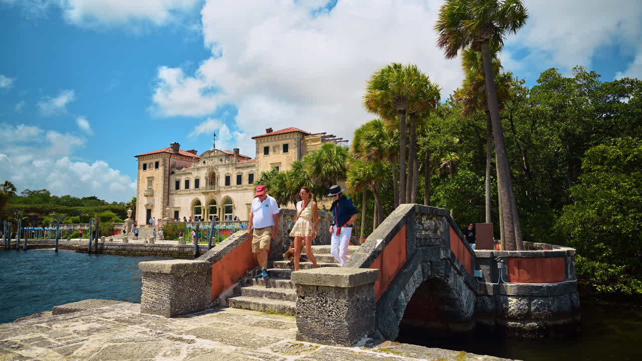 Miami, USA, 16. huhtikuuta 2026: Ihmisiä kävelemässä kivisillan yli Vizcayan museossa Miamissa. Turisteja korallikivisillalla historiallinen Vizcayan museo ja puutarha -kartano taustalla Miamissa