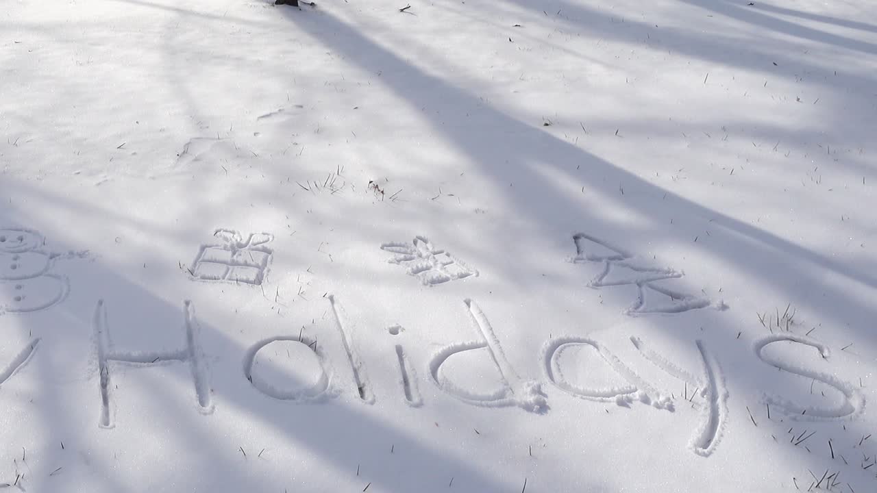 Inscription of happy holidays on snow. Shooting in the winter