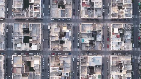 imágenes aéreas estáticas de edificios y coches que pasan por la ciudad de monopoli, italia