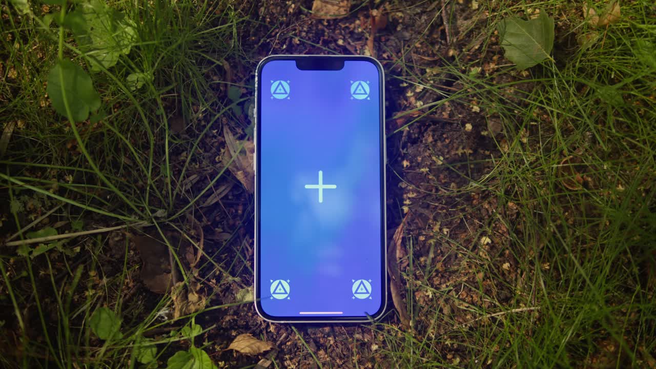 Phone with chroma key screen on the earth ground close-up. Green screen on smart phone. Nature