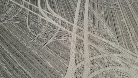drone shot of tracks in a sand field.
