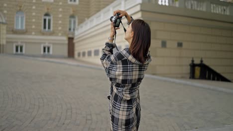 woman taking a photo with a camera in the street