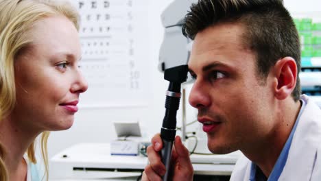 primer plano del optometrista mirando a través del oftalmoscopio
