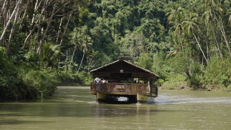 Slow-motion-shot-of-a-river-cruise-boat-taking-tourists-through-the-jungle-in-Bohol