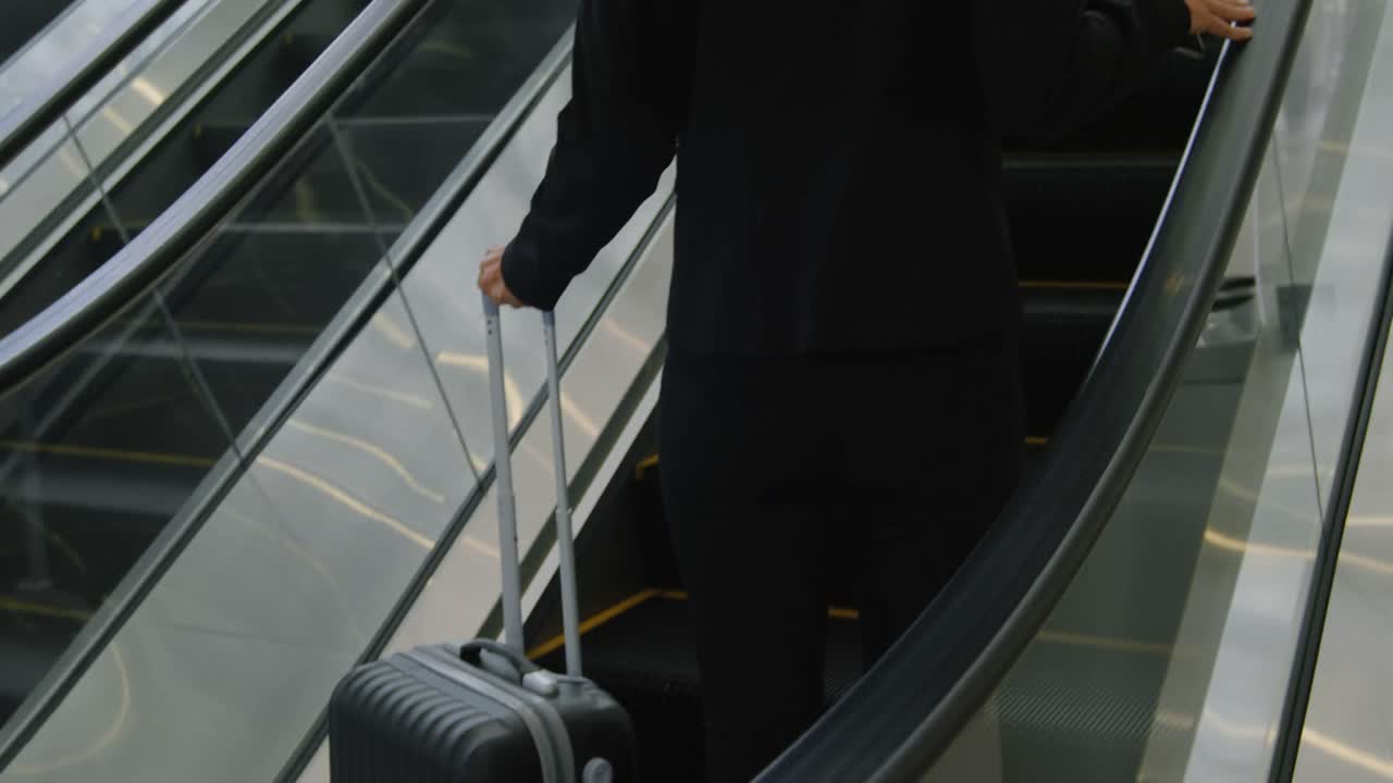 Businesswoman with suitcase going up on elevator in office 4k
