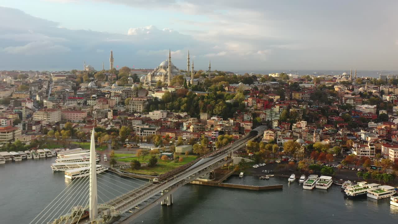 amplia vista aérea un tren que cruza el puente del metro halic y el río bósforo en una colorida y vibrante mañana de amanecer en estambul turquía con la hagia sophia en la distancia en una colina