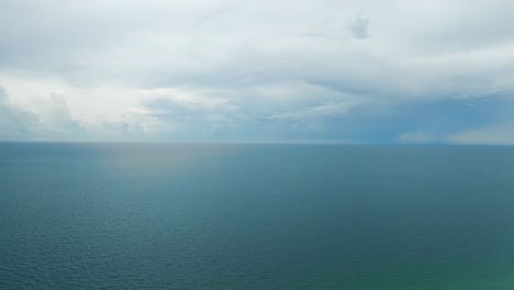 Movimiento-Lento-Y-Directo-En-El-Océano-Del-Golfo-De-México-Desde-La-Playa-De-Romero-Con-Cielo-Azul-Nublado-Y-Luz-Solar-Entrando