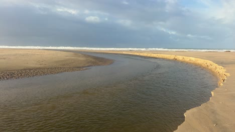 Un-Canal-Que-Serpentea-A-Lo-Largo-De-La-Costa-De-Zahara-En-España,-Mostrando-El-Proceso-De-Erosión-Natural.