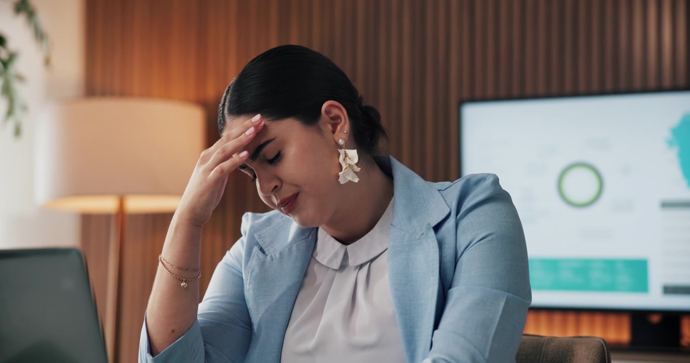 Stressed Businesswoman Working on Laptop in Office