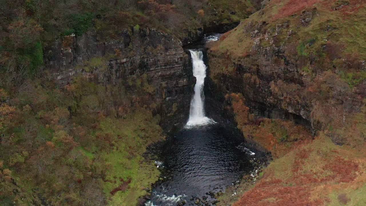vuelo de drones aéreos en cámara lenta de la cascada de otoño lealt en skye escocia otoño