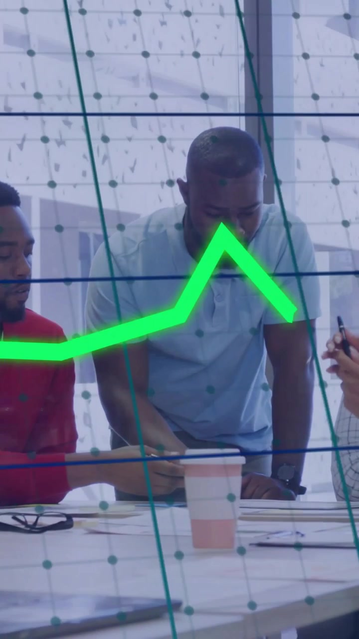 Vertical video: Lead leaning over table pointing papers sparking neon charts across glass for biz
