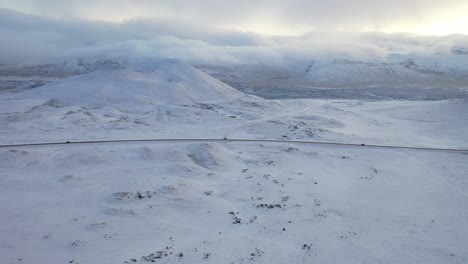 Antenne-Von-Autos,-Die-Auf-Einer-Schneebedeckten-Autobahn-Durch-Berge-In-Island-Fahren?