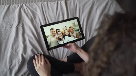 woman viewing friends' selfie on tablet