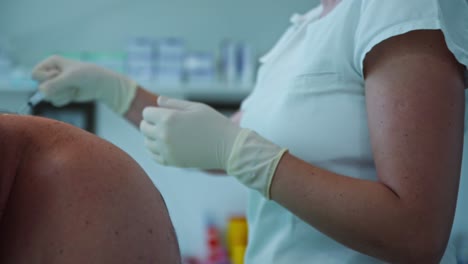 doctor working on a patient with a syringe