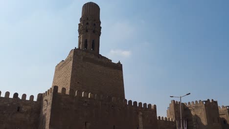 view of bāb al-futuh, "the gate of conquest", fortified gates of cairo from medieval times. cairo, egypt. low angle, hand held.