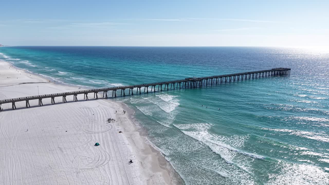 Volo panoramico di drone sulla spiaggia pubblica di Panama City, con un lungo molo che si estende nel Golfo del Messico, Panama City Beach, Florida, USA.