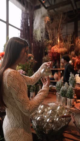 woman choosing christmas ornament in a flower shop