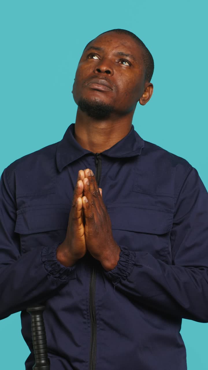 Man in Uniform with Baton Prays Looking Up