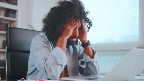 young worried arabian man nervous waiting for letter in laptop sits in office